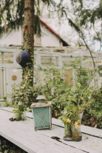 Garden table with glasses and decoration: lantern, flowers and twigs Garden table with glasses and decoration: lantern, flowers and twigs